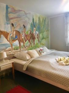 un dormitorio con un mural de tres hombres montando caballos en Dworek Wymysłowo, en Tuchola