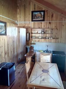 cocina con mesa y fregadero en una habitación en Cabañas Sol de Montañas, en Futaleufú