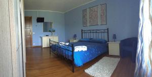 1 dormitorio con 1 cama, paredes azules y suelo de madera en bed and breakfast "il Picchio Verde", en Cittaducale