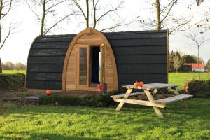 une petite cabine avec une table de pique-nique devant elle dans l'établissement Trekkershut, à Jubbega-Schurega