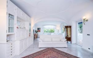 a white living room with a white couch and a rug at Villa Marinella in Ischia