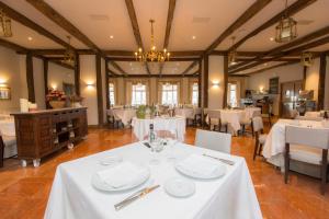 une salle à manger avec des tables et des chaises blanches dans l'établissement Parador de Ribadeo, à Ribadeo