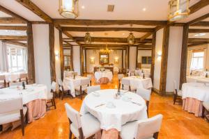 une salle à manger avec des tables et des chaises blanches dans l'établissement Parador de Ribadeo, à Ribadeo