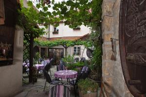 um pátio exterior com mesas e cadeiras roxas em Hotel Altdeutsche Weinstuben em Freyburg