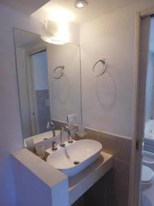 y baño con lavabo y espejo. en Complejo Solvang en Ostende