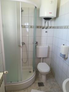 a bathroom with a toilet and a glass shower at Apartmani Pami in Podstrana