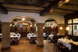 a restaurant with tables and chairs in a room at Hotel Altdeutsche Weinstuben in Freyburg