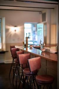 a bar with a row of stools in a kitchen at Troutbeck in Amenia +61 photos