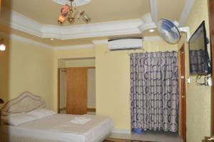 una camera d'albergo con letto e tenda di Hotel Reyadha International a Cox's Bazar