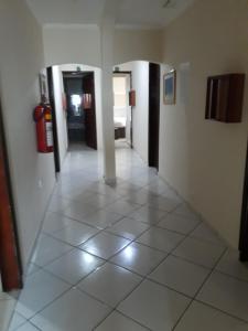 a room with a door open and a door to a hallway at Hotel tenda 1 in Guarulhos