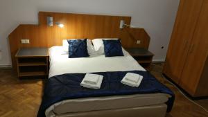 - une chambre avec un grand lit et des oreillers bleus dans l'établissement Martha Residence, à Sibiu
