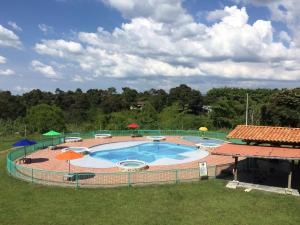 a large swimming pool with umbrellas in a yard at Hotel Campestre Paraiso Cafetero in Montenegro +43 photos
