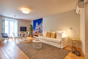 un soggiorno con divano bianco e tavolo di Modern Apartment Bica dos Olhos a Lisbona