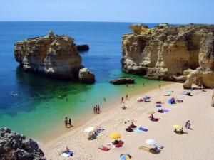 a group of people on a beach with umbrellas at AlgarveFlat in Albufeira