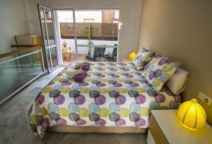 a bedroom with a bed with a colorful comforter at DescubreHome Sol Town Center Private Terrace in Seville