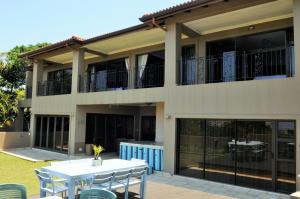 a house with a table and chairs in front of it at Hilken Lodge in Durban