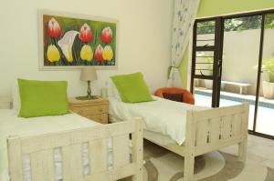 two beds in a room with a painting on the wall at Hilken Lodge in Durban
