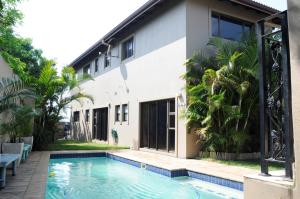 a house with a swimming pool next to a building at Hilken Lodge in Durban