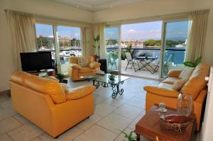 a living room with orange furniture and a balcony at Marina Banderas Suites Hotel Boutique in Nuevo Vallarta