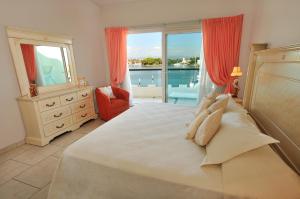 a bedroom with a large bed with a view of the ocean at Marina Banderas Suites Hotel Boutique in Nuevo Vallarta