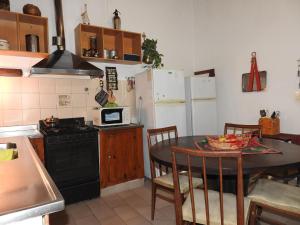 a kitchen with a table and a stove and refrigerator at La Loberia - Las Grutas in Las Grutas
