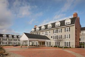 a large white building with a black roof at Westford Regency Inn & Conference Center in Westford