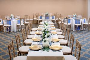 a row of tables and chairs with blue and white flowers at Westford Regency Inn & Conference Center in Westford