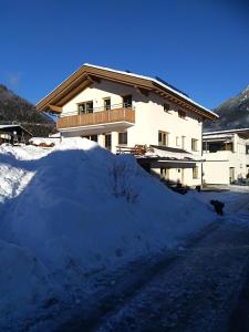 a pile of snow in front of a house at s`Haus am Inn in Pfunds