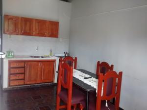 a kitchen with a table and chairs and a kitchen with a sink at Guatambu Apart in Puerto Iguazú