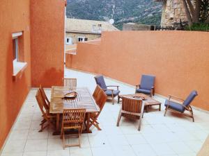 eine Terrasse mit Holztischen und -stühlen auf dem Balkon in der Unterkunft Casa Suprana in Partinello