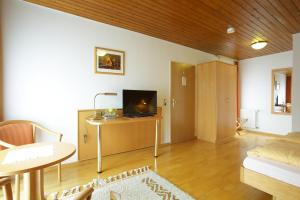 a living room with a television and a table in a room at Hotel-Restaurant Gasthof Adler in Neuenburg am Rhein