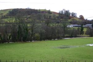 a green field with a hill in the background at The Tanners Arms in Devynock