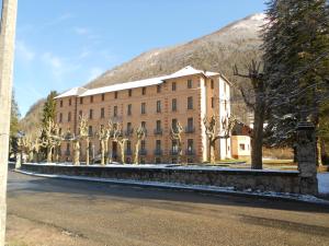 a large building with a mountain in the background at Aulus-les-Bains in Aulus-les-Bains