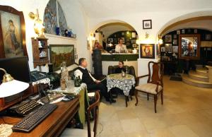 zwei Personen sitzen an einem Tisch in einem Zimmer in der Unterkunft Hotel Senator-Ház Eger in Eger