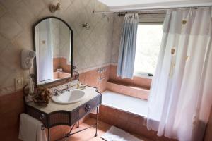 
a bathroom with a tub, sink and mirror at Don Numas Posada & Spa in San Lorenzo
