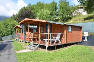a small house with chairs and a porch at Camping Adamello in Edolo