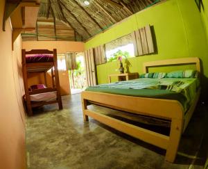a bedroom with a bed with a green wall at Cabañas Ecoturisticas Y Club Gaira Tayrona in Santa Marta +68 photos