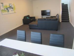 
a living room filled with furniture and a flat screen tv at Abel Tasman Airport Motor Inn in Launceston
