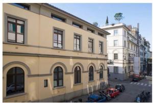 a large building with cars parked in front of it at The Golden Tree in Florence