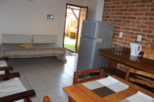 a kitchen with a refrigerator and a table and chairs at Un Lugar Hotel Cabañas in Eldorado