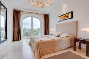 a bedroom with a large bed and a large window at Arcos Gardens Sol Rent Golf in Arcos de la Frontera