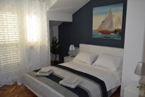 a bedroom with a large bed with a sailboat on the wall at Apartments Bazina in Kaštela