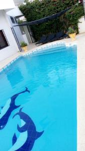 a swimming pool with two dolphins in the water at Villa Massilia in Saly Portudal