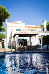 ein Haus mit einem Pool vor einem Haus in der Unterkunft Coreto's Village in Praia Verde