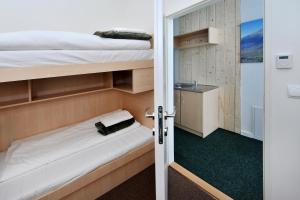 a room with two bunk beds and a bathroom at Bel Hostel in Tatranská Lomnica