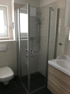 een badkamer met een douche, een toilet en een wastafel bij Ferienwohnung Zweisamkeit in Graal-Müritz