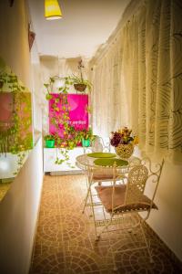 a dining room with a table and chairs and flowers at Mozaic Home in Bucharest