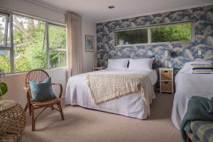 um quarto azul e branco com 2 camas e uma cadeira em Seahurst Apartment em Eskdale