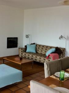 ein Wohnzimmer mit einem Sofa und einem Tisch in der Unterkunft Casa do Mar em Porto Covo in Porto Covo
