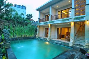 a house with a swimming pool in front of a house at Dewi Putri House in Ubud